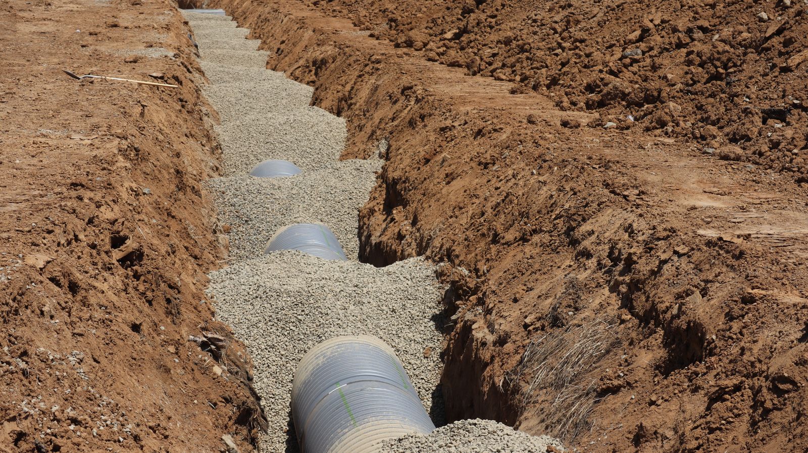 Corrugated drainage pipe in a gravel trench for drain field prep