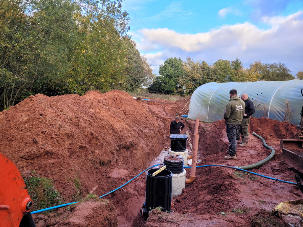 Septic tank installation with black risers in an excavated trench
